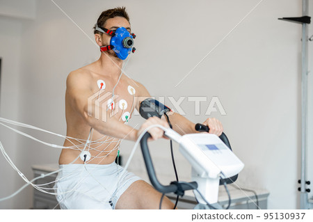 Man examining his cardiovascular system on bike simulator 95130937