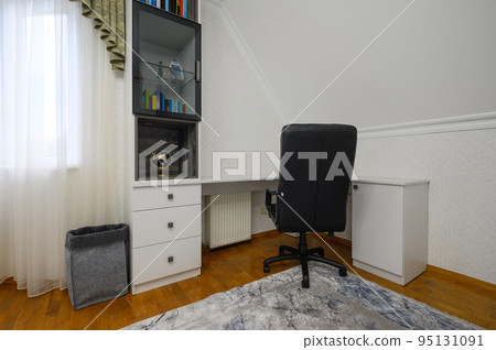 Interior of a large brightly lit comfortable bedroom with domestic workplace 95131091