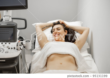 Woman during an ultrasound examination of abdominal cavity 95131199