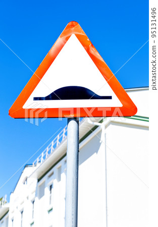 Triangle speed bump road sign against the blue sky Triangle speed bump road sign against the blue sky 95131496