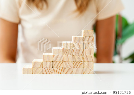 Hand arranging wood cube stacking as step stair. Hand arranging wood cube stacking as step stair. 95131736