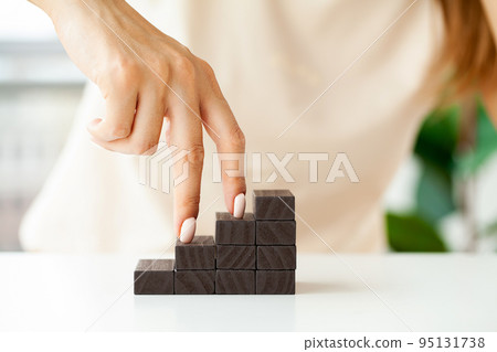 Hand arranging wood cube stacking as step stair. Hand arranging wood cube stacking as step stair. 95131738