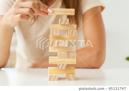 Hand of a young business woman to play wood block game with strategy and business systematic project management 95131747