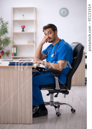 Young male doctor working in the clinic Young male doctor working in the clinic 95131914
