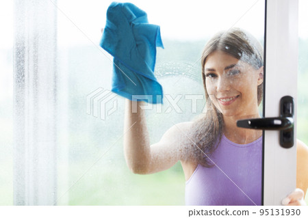 Young Smiling Woman Washing Window with Sponge. Young Smiling Woman Washing Window with Sponge. 95131930