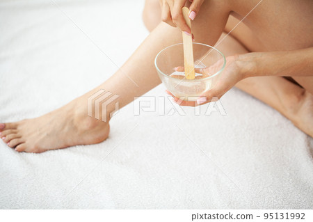 Woman holding bowl with hot wax for depilation epilation hair removal procedure Woman holding bowl with hot wax for depilation epilation hair removal procedure 95131992