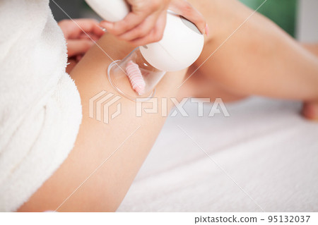 Anti-cellulite massage of the hips with the use of vacuum cans. Anti-cellulite massage of the hips with the use of vacuum cans. 95132037