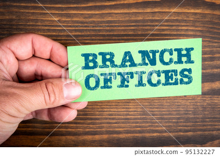 BRANCH OFFICES. Green card with a text in a man's hand BRANCH OFFICES. Green card with a text in a man's hand 95132227
