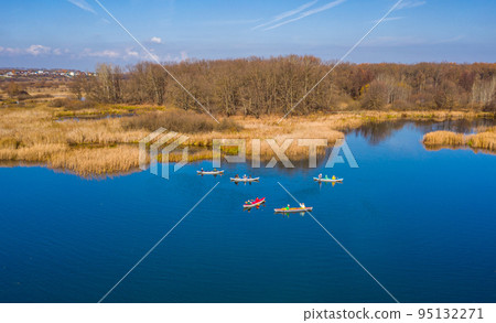 Tourists on colorful kayaks float on the river Tourists on colorful kayaks float on the river 95132271