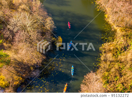Tourists on colorful kayaks float on the river Tourists on colorful kayaks float on the river 95132272