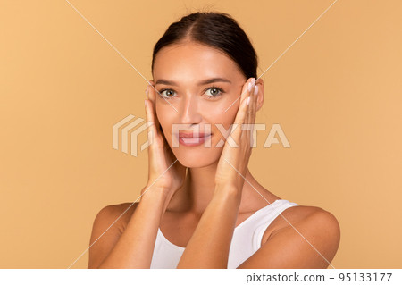 Essential beauty. Portrait of happy lady touching her smooth skin, looking at camera, enjoying result of beauty treatments 95133177