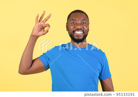 Happy Black Male Gesturing Okay In Approval Over Yellow Background Happy Black Male Gesturing Okay In Approval Over Yellow Background 95133191