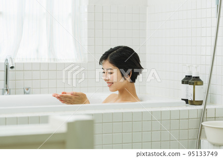 A woman relaxing in a bath at home 95133749