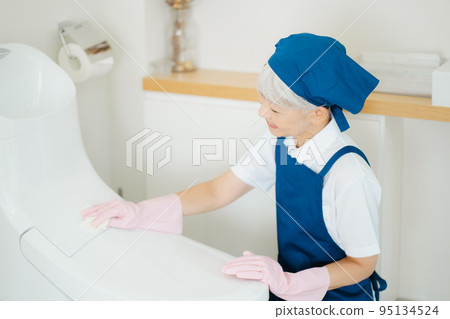 Housekeeper senior woman cleaning the toilet Housekeeper senior woman cleaning the toilet 95134524