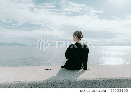 一個女人站在海邊的照片 一個女人站在海邊的照片 95135160