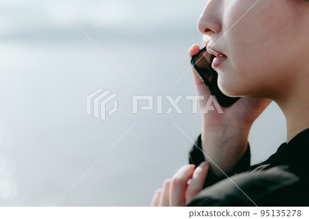 Photo of a woman standing by the sea Photo of a woman standing by the sea 95135278