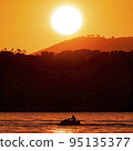 A jet ski on the sea with an orange sunset in the background  95135377