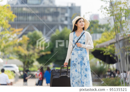 一名年輕女子拉著行李箱在名古屋觀光 一名年輕女子拉著行李箱在名古屋觀光 95135521