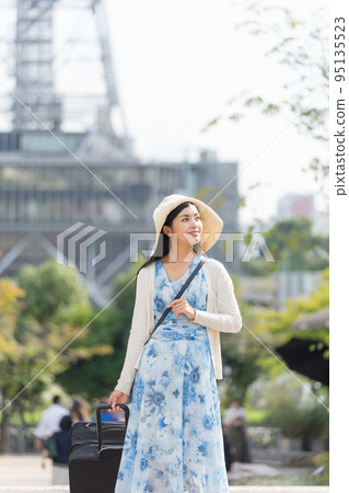 一名年輕女子拉著行李箱在名古屋觀光 95135523