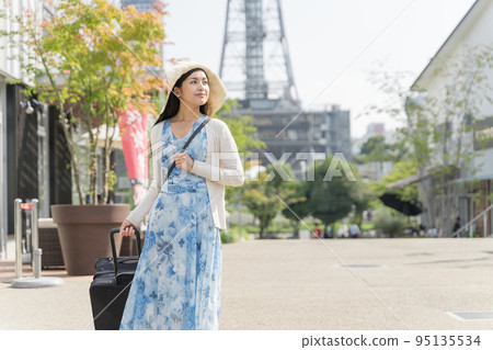 一名年輕女子拉著行李箱在名古屋觀光 95135534