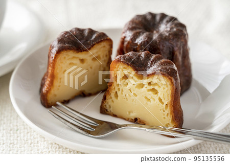白盤上的法式糕點 canelé 白盤上的法式糕點 canelé 95135556