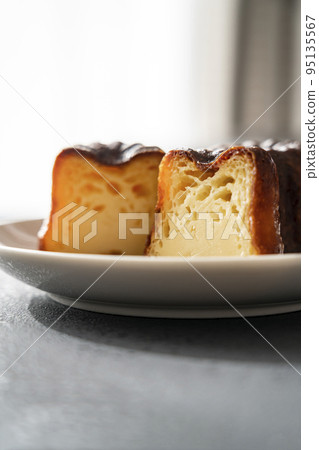 French pastry canelé on a white plate [black background] 95135567