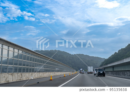 Passenger cars running on the Shin-Tomei Expressway in the morning Mt. Fuji seen beyond the morning fog Passenger cars running on the Shin-Tomei Expressway in the morning Mt. Fuji seen beyond the morning fog 95135638