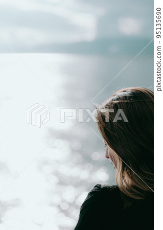 Photo of a woman standing by the sea 95135690