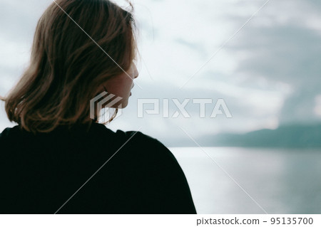 Photo of a woman standing by the sea 95135700