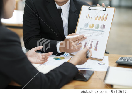 Businessmen working, discussing, analyzing using laptop and graphs. Businessmen working, discussing, analyzing using laptop and graphs. 95136173