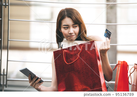 Young asian woman use online payment by credit card and smart phone. 95136789