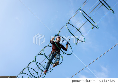 A man is resting in a rope amusement park. Front view. 95137189