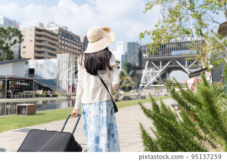 一名年輕女子拉著行李箱在名古屋觀光的背影 一名年輕女子拉著行李箱在名古屋觀光的背影 95137259