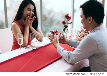 Man couple hand hold a romantic present red gift box give it to girlfriend. 95137294