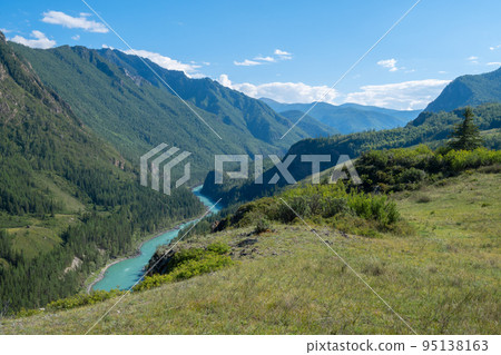 alpine landscape of a valley with a turquoise river from the top of a mountain 95138163