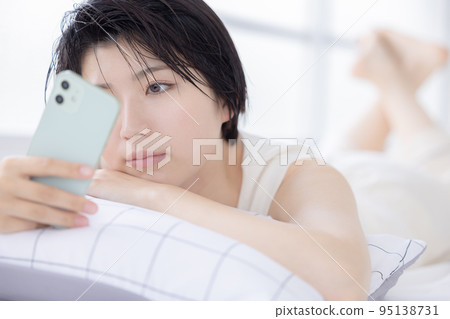 Beauty image A young woman looking at her smartphone 95138731