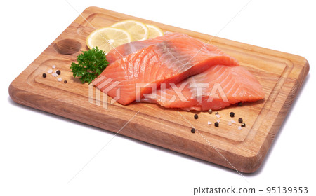 piece of salmon fillet on wooden cutting board isolated on white background piece of salmon fillet on wooden cutting board isolated on white background 95139353