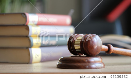 Judge gavel on wooden sounding block and pile of law books Judge gavel on wooden sounding block and pile of law books 95139382