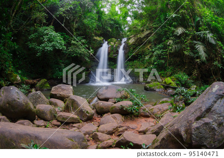 Beautiful woman in red dress in front of the Sapan Waterfall, Khun Nan National Park, Boklua District, Nan Province, Thailand. Beautiful woman in red dress in front of the Sapan Waterfall, Khun Nan National Park, Boklua District, Nan Province, Thailand. 95140471
