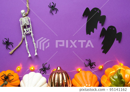 Halloween layout of garland of skeleton on a rope, glowing Jack o Lantern, pumpkins, spiders on a purple background. Flat lay horror and a terrible holiday Halloween layout of garland of skeleton on a rope, glowing Jack o Lantern, pumpkins, spiders on a purple background. Flat lay horror and a terrible holiday 95141162