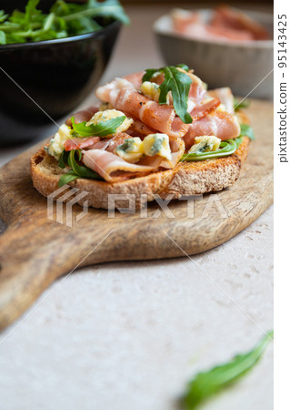 Toast with bacon, fresh arugula and blue cheese Toast with bacon, fresh arugula and blue cheese 95143425
