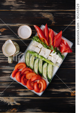 chopped vegetables with goat cheese on a plate 95143529
