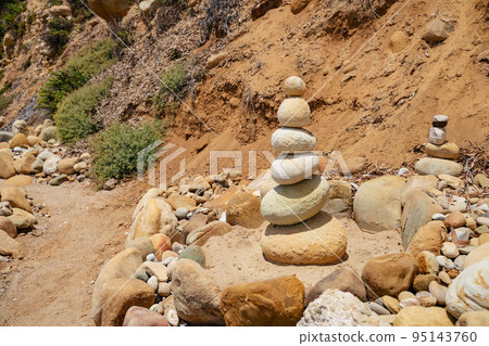 Stack of balanced light yellow and beige stones at Butterfly beach in Santa Barbara California. Health pyramid peace and balance in nature lifestyle Stack of balanced light yellow and beige stones at Butterfly beach in Santa Barbara California. Health pyramid peace and balance in nature lifestyle 95143760