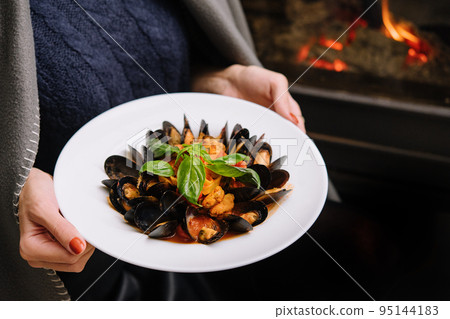 Delicious fresh steamed mussels in white wine sauce in a white plate Delicious fresh steamed mussels in white wine sauce in a white plate 95144183