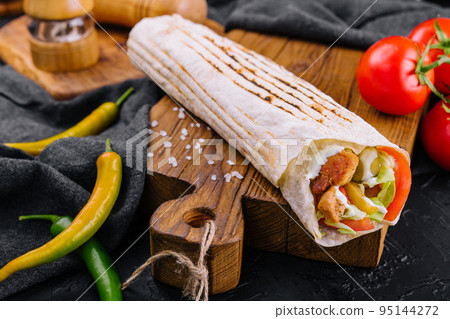Shawarma rolled in lavash, moist grilled meat Shawarma rolled in lavash, moist grilled meat 95144272
