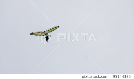 Ultralight trike flies in the sky. 95144383