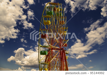 Attraction (carousel) ferris wheel against the background of a romantic evening sky Attraction (carousel) ferris wheel against the background of a romantic evening sky 95144992