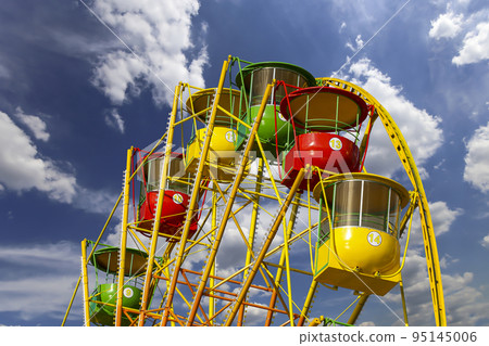 Attraction (carousel) ferris wheel on the background of the cloudy sky 95145006