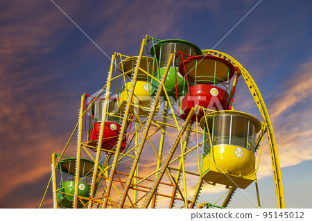 Attraction (carousel) ferris wheel against the background of a romantic evening sky Attraction (carousel) ferris wheel against the background of a romantic evening sky 95145012
