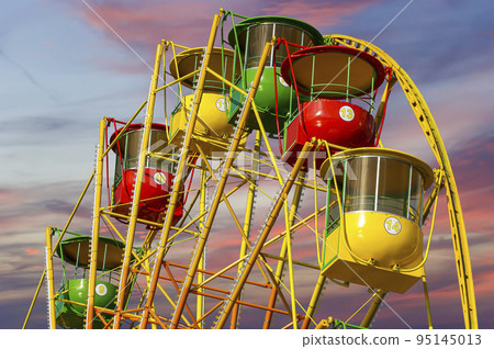 Attraction (carousel) ferris wheel against the background of a romantic evening sky Attraction (carousel) ferris wheel against the background of a romantic evening sky 95145013